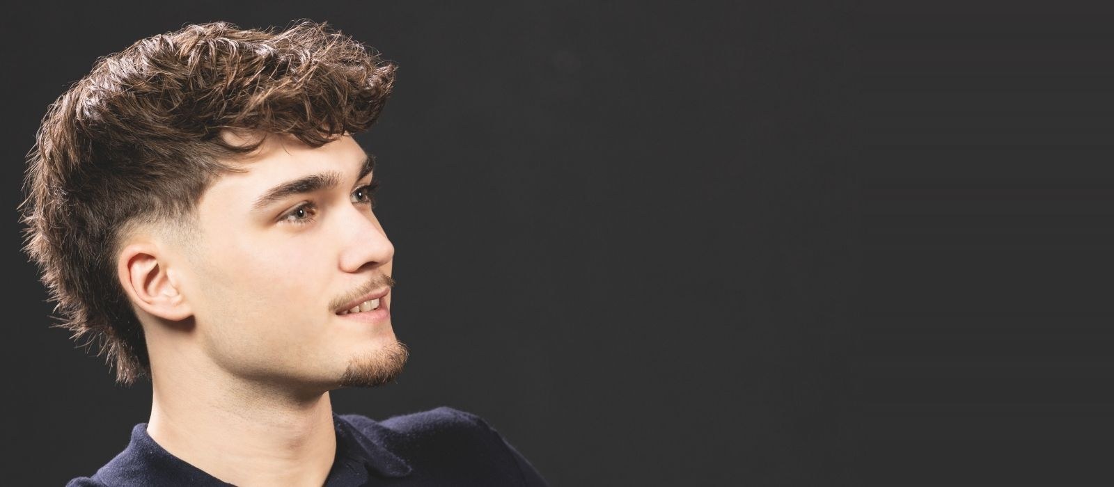 Coiffure homme — coupe dégradée sur fond sombre